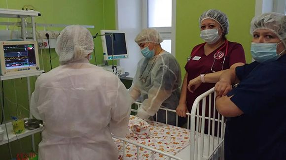 Ольга Юрьевна с коллегами у кроватки спасенного малыша.jpg